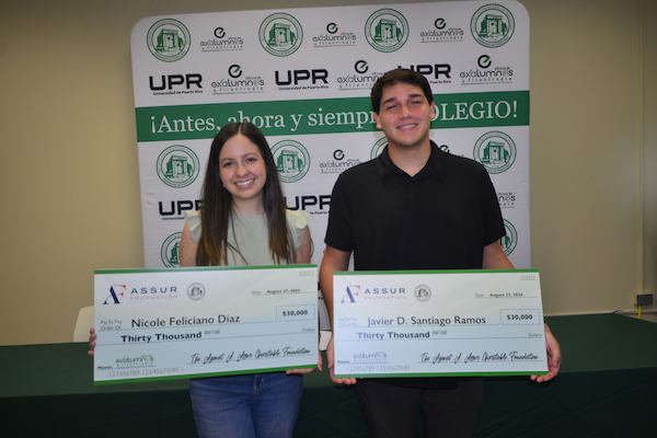 Nicole Feliciano Díaz y Javier D. Santiago Ramos muestran los cheques de las primeras becas que ganaron de la Fundación Azmat A. Assur.