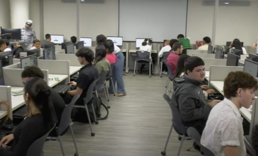 Estudiantes de Aguas Buenas sentados en cubículos tomando los talleres.